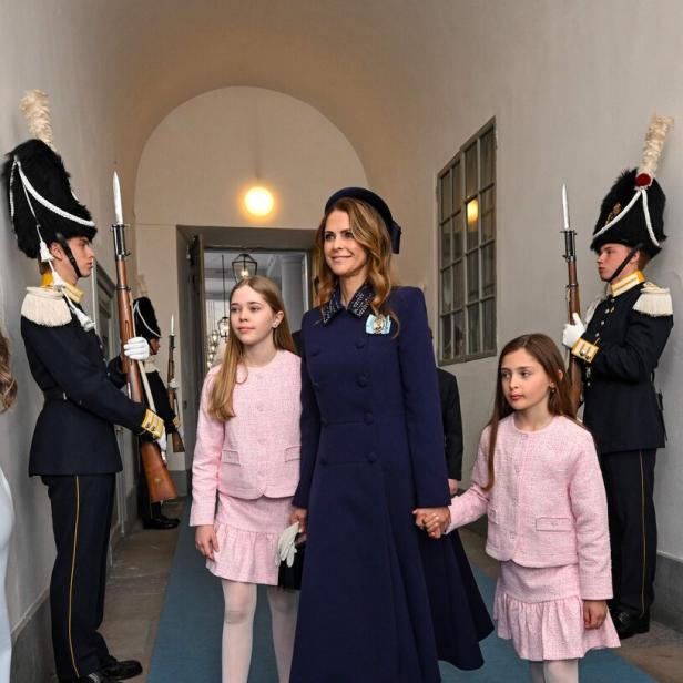 Prinzessin Madeleine von Schweden geht mit ihren Töchtern Leonore und Adrienne an zwei Wachen in Uniform vorbei.