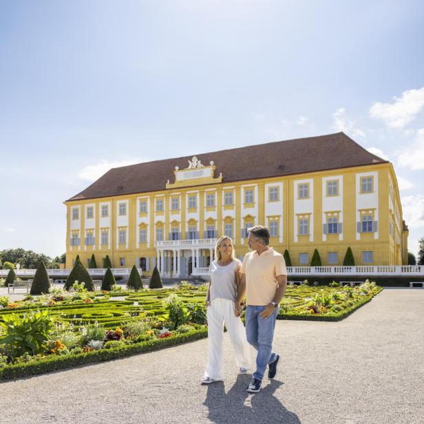 Paar spaziert vor Schloss Hof durch den Barockgarten.