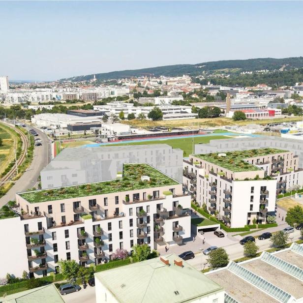 Luftaufnahme eines Stadtviertels mit geplanten Wohnhäusern, Straßen und Hügeln im Hintergrund.