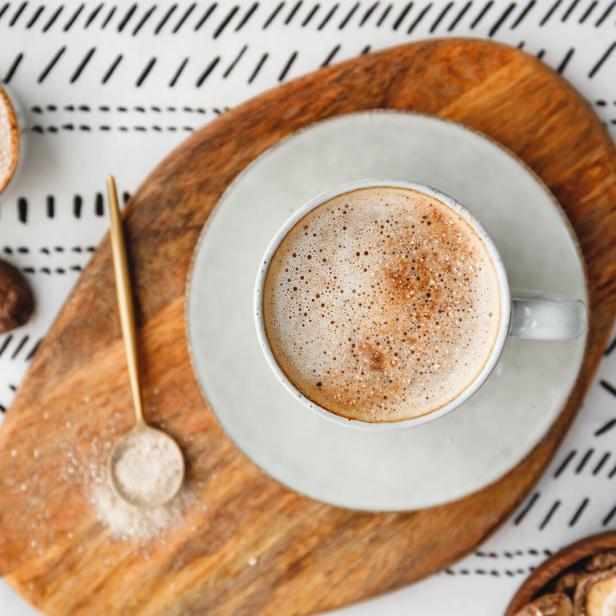 Top view of mushroom latte with Shiitake powder and unsweetened coconut-almond blend milk. Healthy useful vegan drink, flat lay.