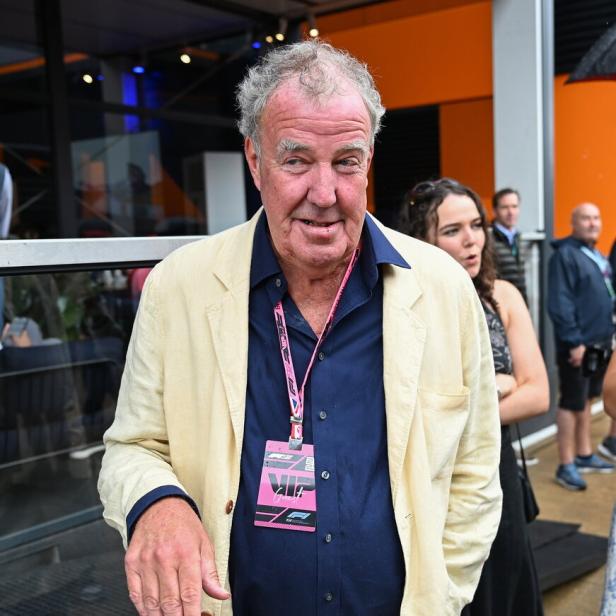 Jeremy Clarkson trägt ein helles Sakko und einen VIP-Ausweis der Formel 1 bei einer Veranstaltung.