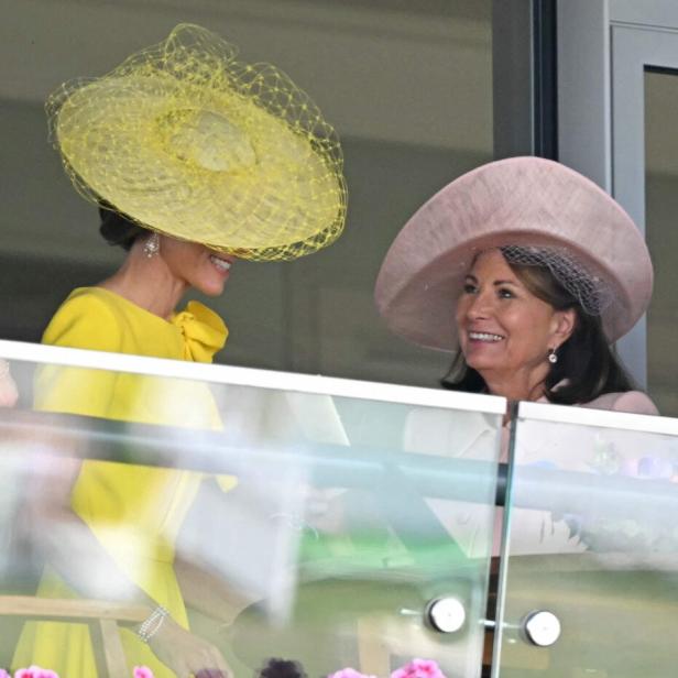 Catherine, Prinzessin von Wales, und ihre Mutter Carole Middleton unterhalten sich lächelnd auf einem Balkon mit Blumen.