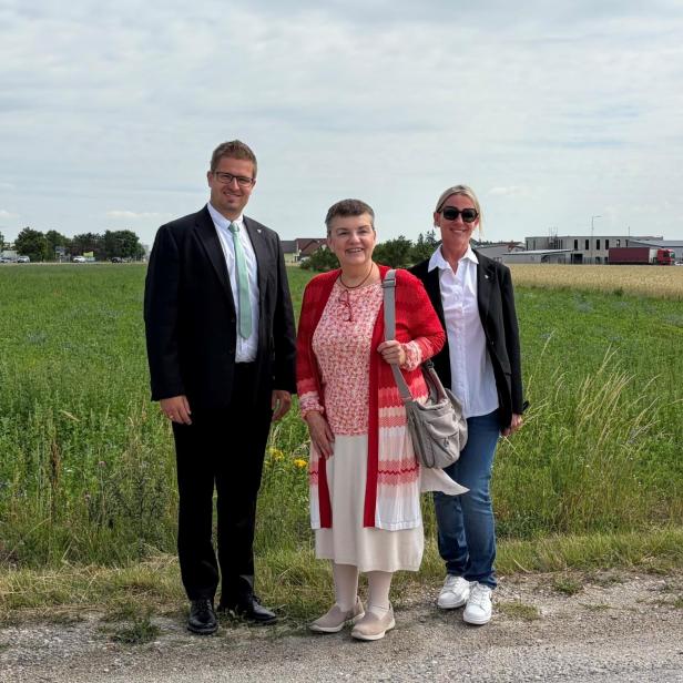 Ein Mann und zwei Frauen stehen vor einem Feld