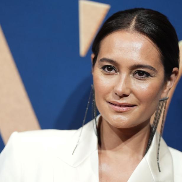 Emma Heming Willis posiert vor blauem Hintergrund bei einer Hollywood-Veranstaltung.