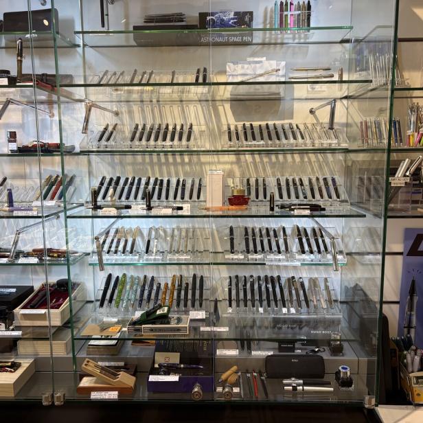 Glasvitrine mit vielen stilvollen Füllfederhaltern und Kugelschreibern verschiedener Marken.