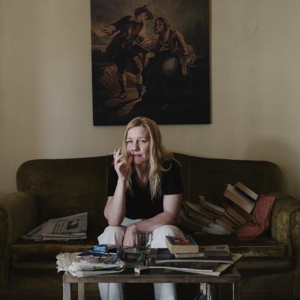 Sandra Hüller als Ingeborg Bachmann, rauchend auf einem Sofa.