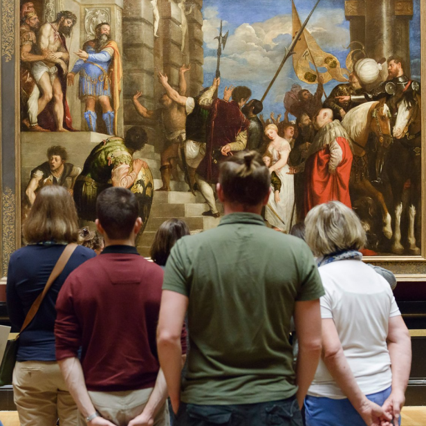 Besucher im Kunsthistorischen Museum betrachten ein großes Historiengemälde mit Soldaten, Reitern und Jesus.
