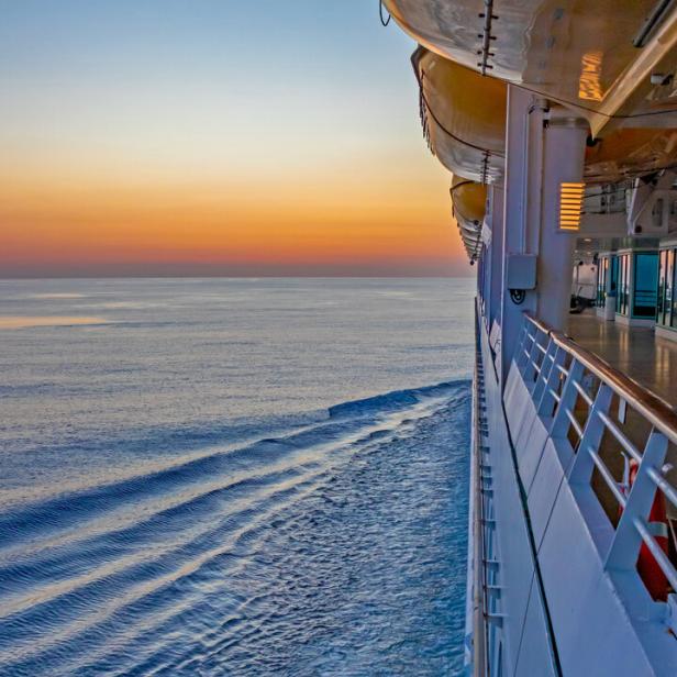 Blick vom Kreuzfahrtschiff auf das ruhige Meer bei Sonnenuntergang.