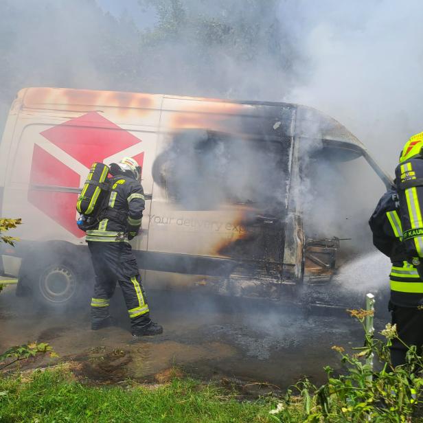 Zwei Feuerwehrmänner löschen den Pkw.