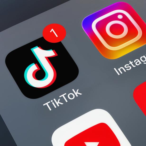 Smartphone-Startbildschirm mit TikTok-, Instagram- und weiteren App-Icons, TikTok mit roter Benachrichtigung „1“.