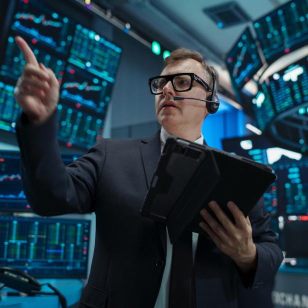 Portrait of a Professional Male Trader Working on Stock Exchange. Enthusiastic Middle Aged Man Shouting, Signaling Orders for Company Shares and Commodities to Brokers at an Open Outcry Arbitrage