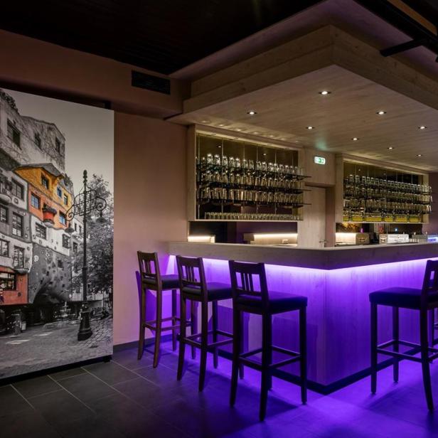 Leere Bar mit violett beleuchtetem Tresen in moderner Eventlocation.