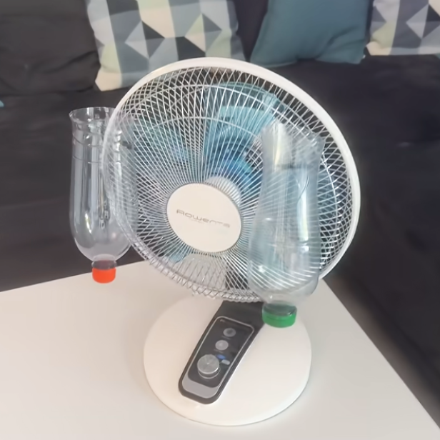 Ventilator mit zwei leeren Plastikflaschen, die vorne am Gitter befestigt wurden