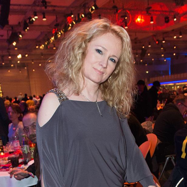 Sängerin Nicole mit langen blonden Haaren bei einer Veranstaltung in einem festlich beleuchteten Saal.