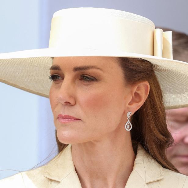 Prinzessin Kate trägt einen cremefarbenen Hut und passende Ohrringe.