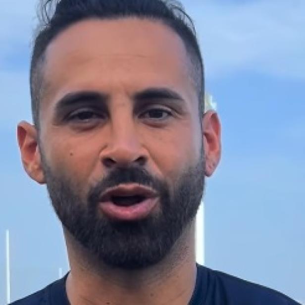 Lucas Trejo schaut ernst in die Kamera vor einem blauen Himmel.