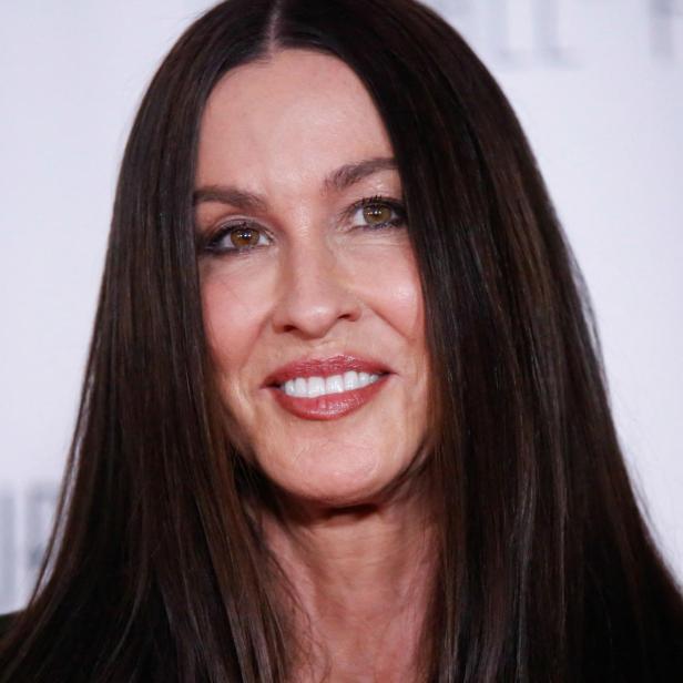 Alanis Morissette lächelt in die Kamera vor einem hellen Hintergrund.