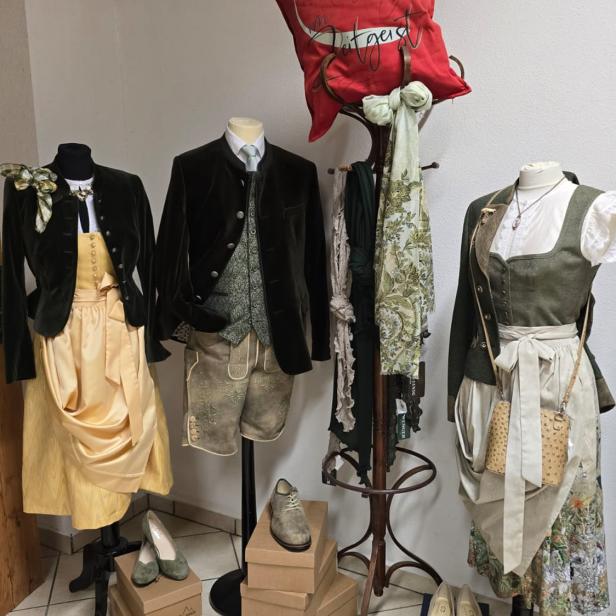 Schaufensterpuppen mit Dirndl, Trachtenjanker und Lederhose in einem Trachtengeschäft.