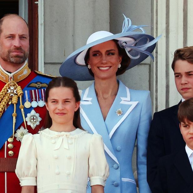 Prinz William, Prinzessin Kate und ihre Kinder George, Charlotte und Louis stehen gemeinsam auf einem Balkon.