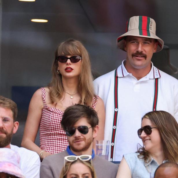 Taylor Swift und Travis Kelce sitzen gemeinsam in einer Loge und schauen auf ein Sportereignis.