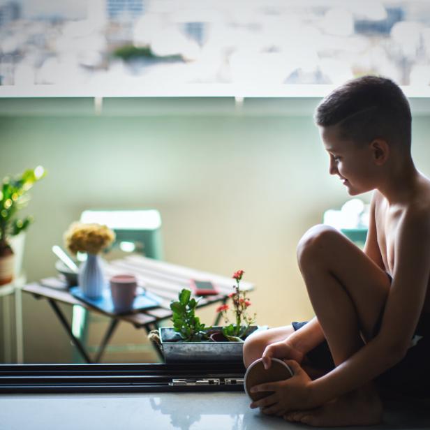 Boy Finds Joy Sitting by the Window.