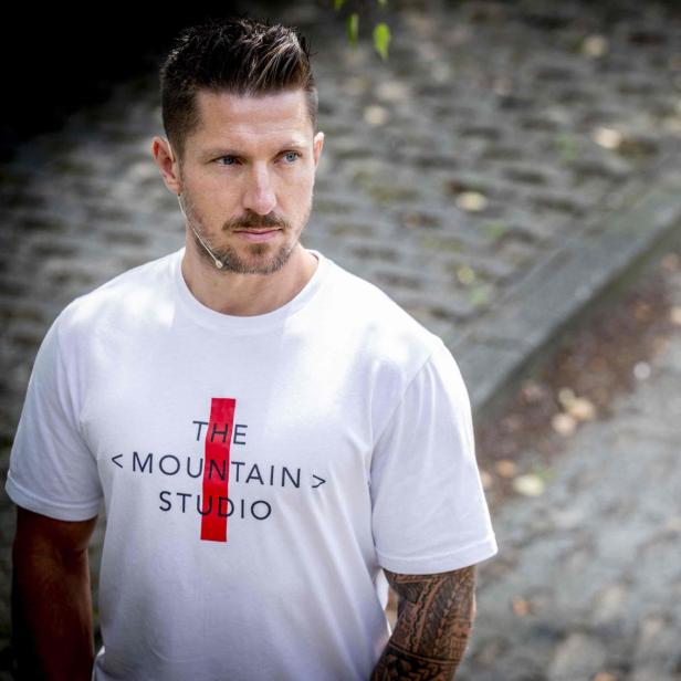 Marcel Hirscher steht draußen vor unscharfem Hintergrund und blickt nach links.