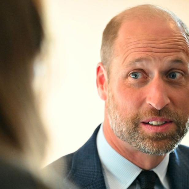 Prinz William blickt während eines Gesprächs aufmerksam zur Seite.