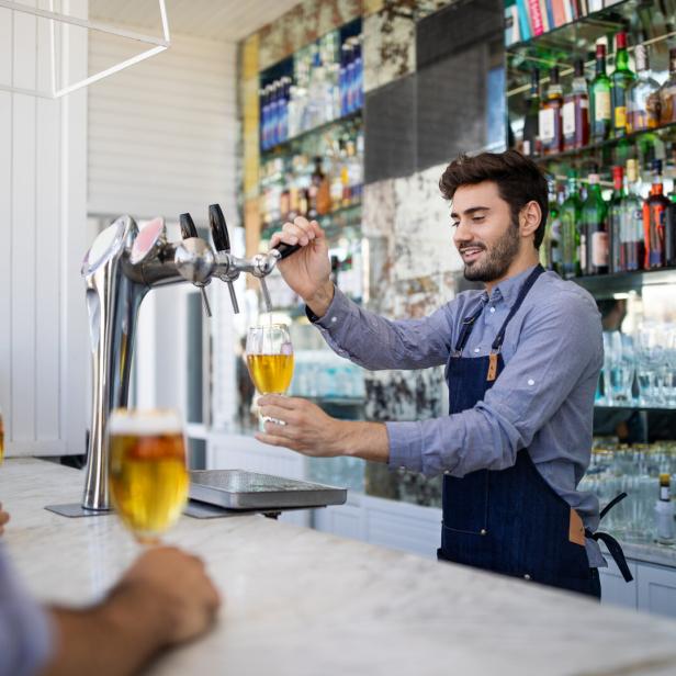 Bartender filing beer in a glass from tap
