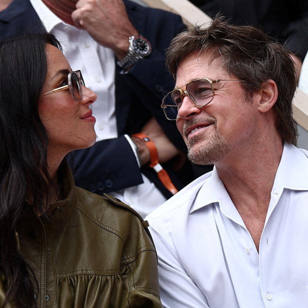 Brad Pitt und Ines de Ramon sitzen nebeneinander und schauen sich lächelnd an.