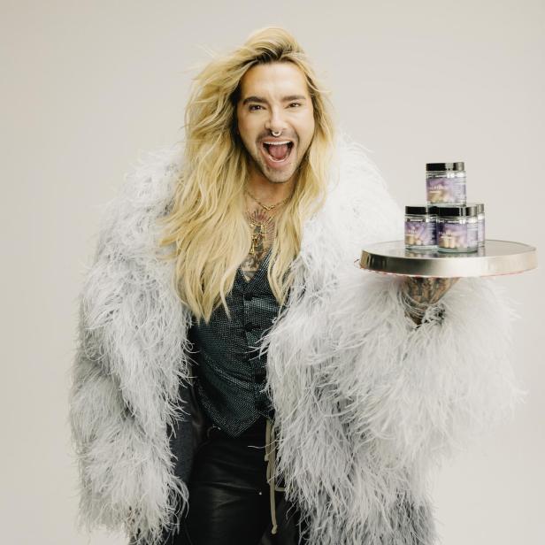 Bill Kaulitz hält ein Tablett mit mehreren Dosen seines Nahrungsergänzungsmittels "BillPill".