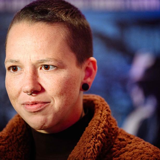 Stefanie Heinzmann mit kurz geschorenen Haaren und Septum-Piercing vor unscharfem Hintergrund.