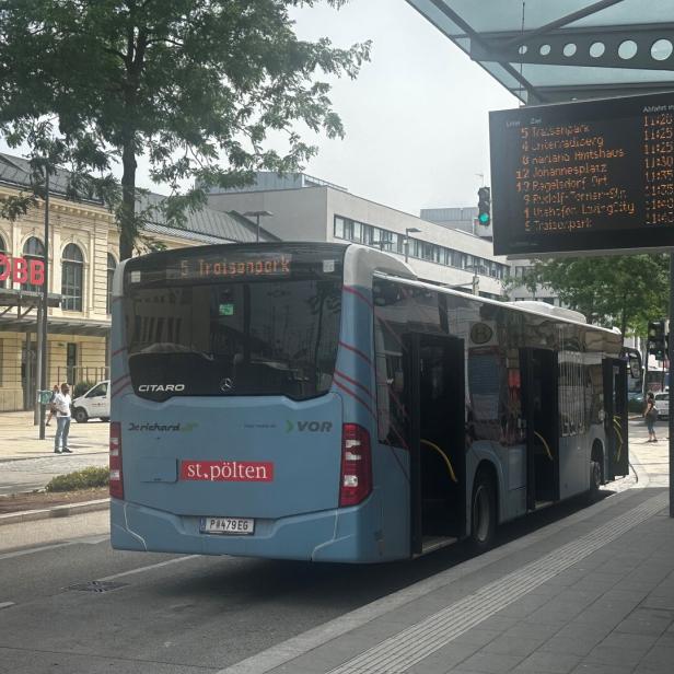 Bushaltestelle in St. Pölten mit wartendem Linienbus und digitaler Abfahrtsanzeige.