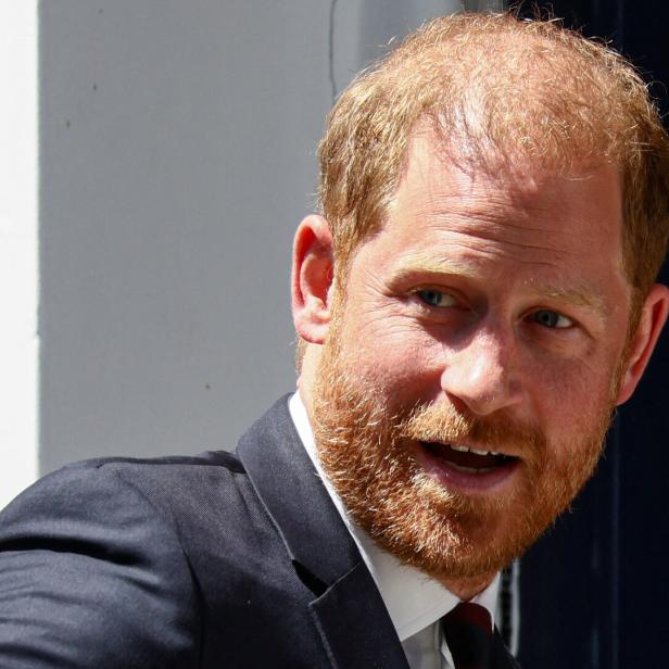 Prinz Harry mit Vollbart und im Anzug blickt zur Seite.