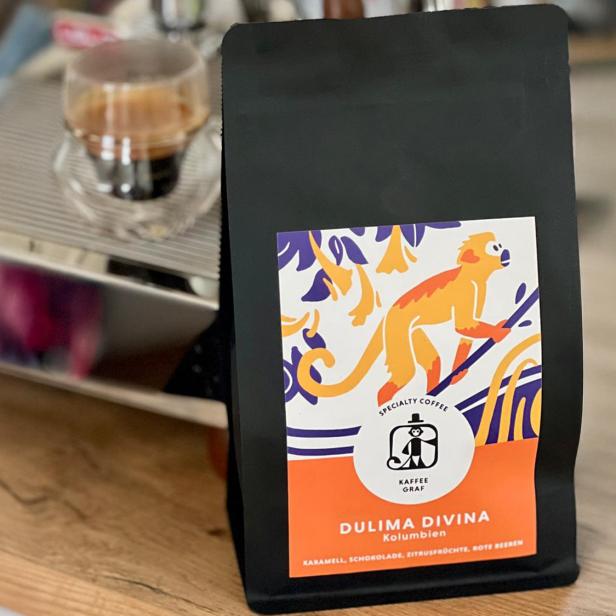 Packung mit Kaffeebohnen vor einer Espressomaschine.