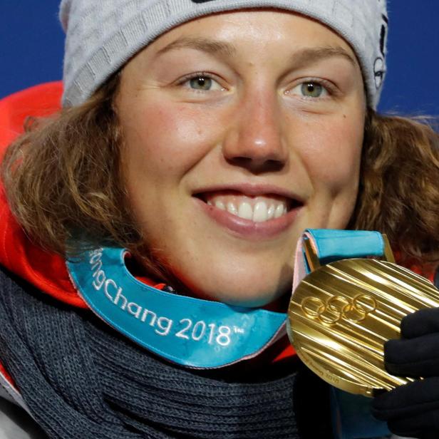 Laura Dahlmeier hält eine Goldmedaille der Olympischen Winterspiele 2018 in Pyeongchang vor ihr Gesicht.