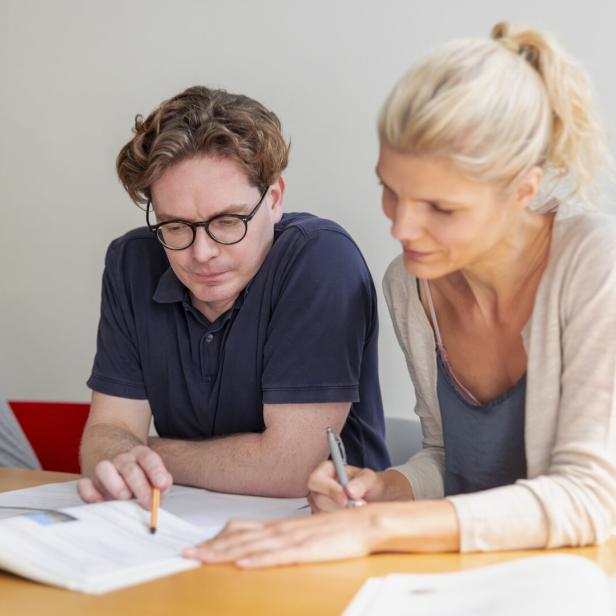 Two students learning foreign language in adult education classroom