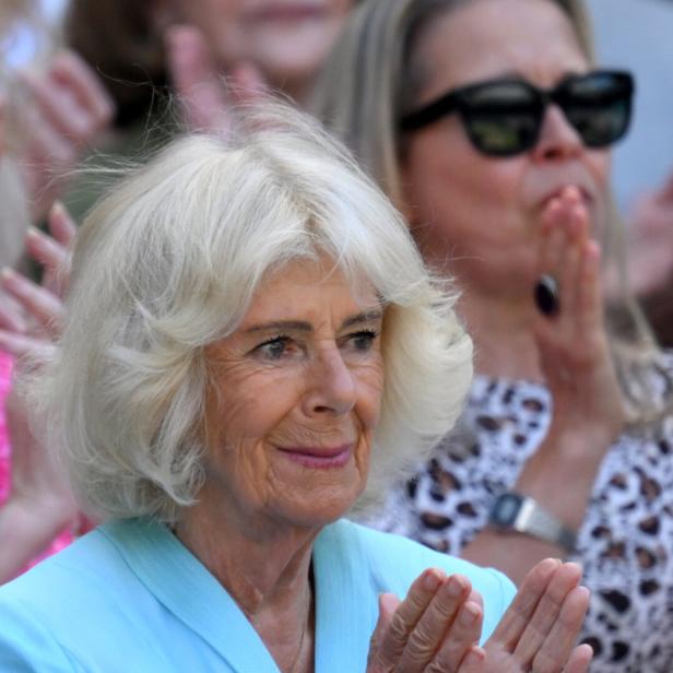 Königin Camilla applaudiert bei einer Veranstaltung, umgeben von weiteren Personen im Publikum.