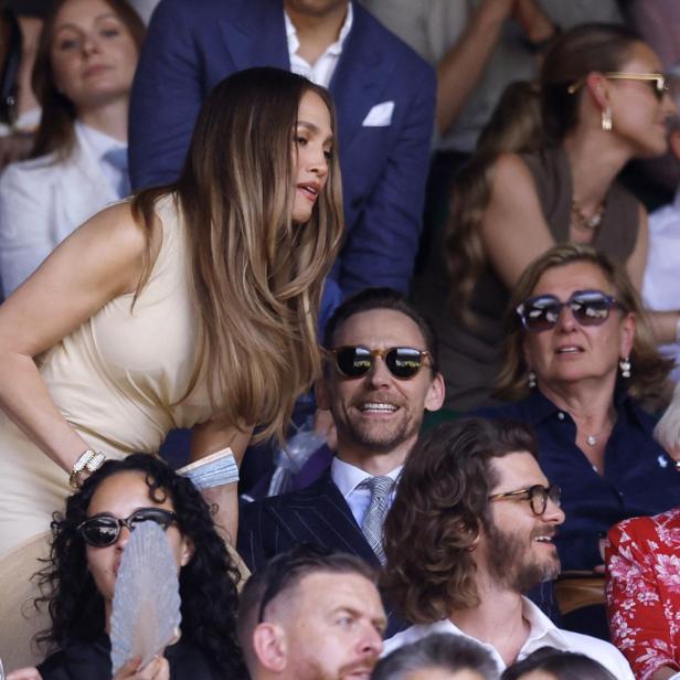 Jennifer Lopez und Tom Hiddleston sitzen auf der Zuschauertribüne bei einem Tennisturnier in Wimbledon.