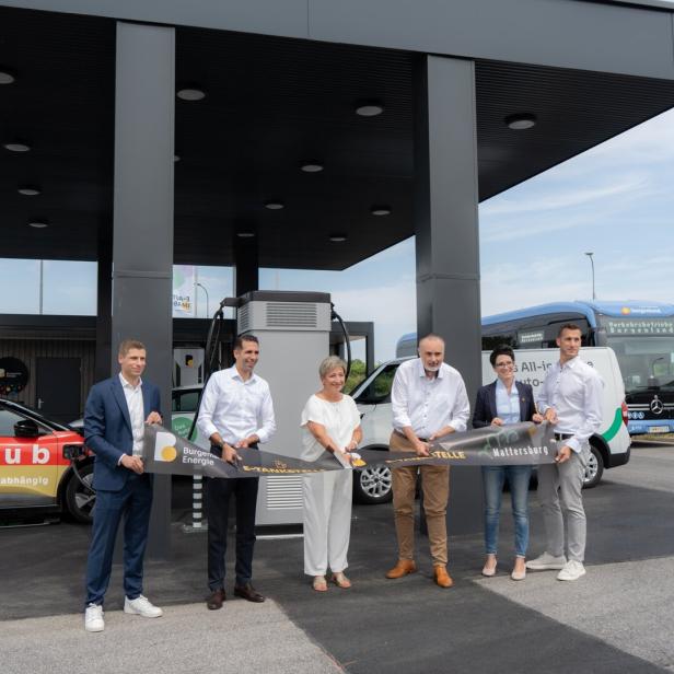 Sechs Personen durchschneiden feierlich ein Band zur Eröffnung einer E-Tankstelle der Burgenland Energie in Mattersburg.