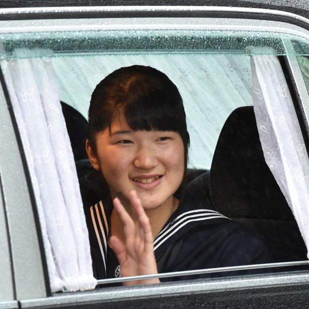 Prinzessin Aiko von Japan winkt lächelnd aus dem Fenster eines Autos.