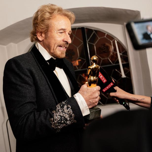 Thomas Gottschalk hält eine goldene Trophäe in die Mikrofone des Kurier.
