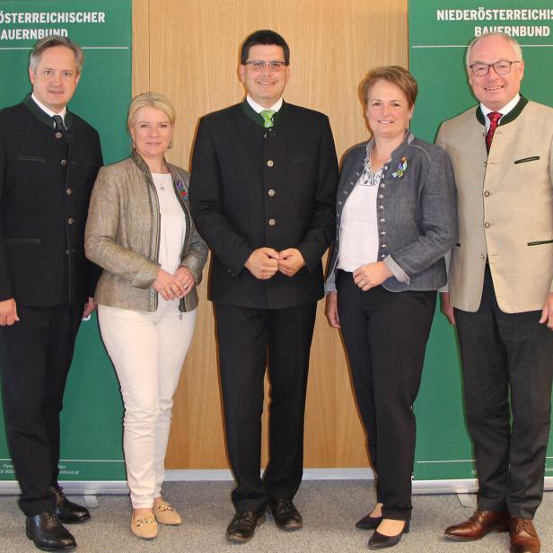 Fünf Personen in Tracht stehen vor Bannern des Niederösterreichischen Bauernbunds.