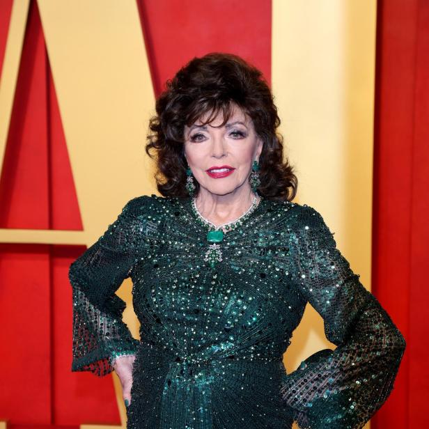 Joan Collins trägt ein funkelndes, smaragdgrünes Abendkleid vor einem roten Hintergrund.