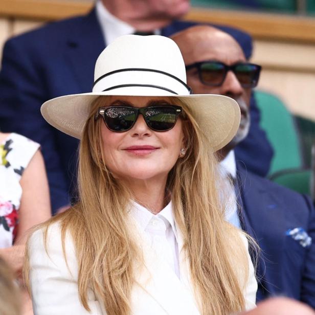 Nicole Kidman trägt einen weißen Hut und einen weißen Blazer, während sie auf der Tribüne in Wimbledon sitzt.