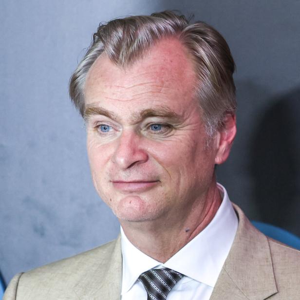 Der Regisseur Christopher Nolan blickt mit einem leichten Lächeln zur Seite.