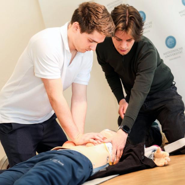 Das Bild zeigt zwei Medizinstudenten der Med Uni Innsbruck bei der Reanimation einer weiblichen Simulationspuppe.