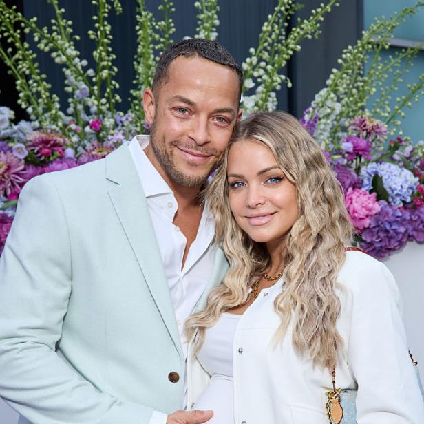Andrej Mangold und Annika Jung posieren bei einem Termin und halten sichtbar den Babybauch.