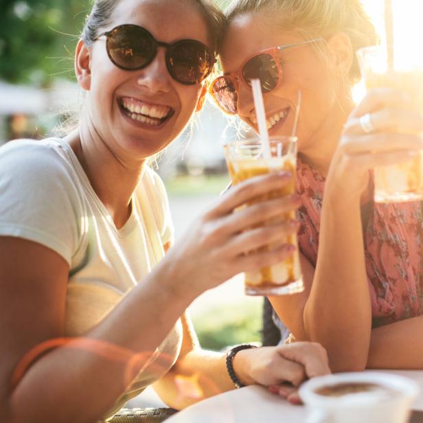 Zwei Frauen trinken gemeinsam einen Cocktail.