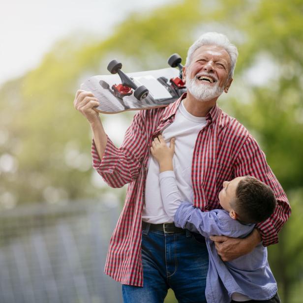 Grandfather and grandson having fun, skateboarding