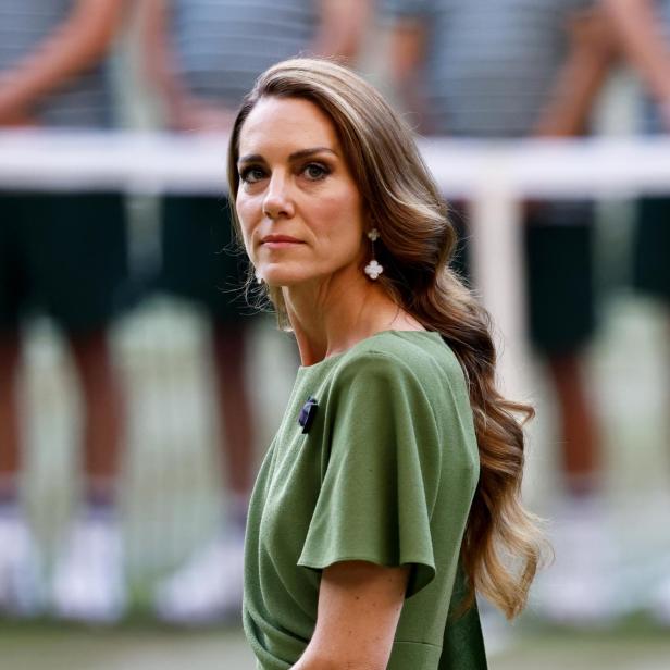 Catherine, Prinzessin von Wales, trägt ein olivgrünes Kleid und blickt ernst zur Seite.